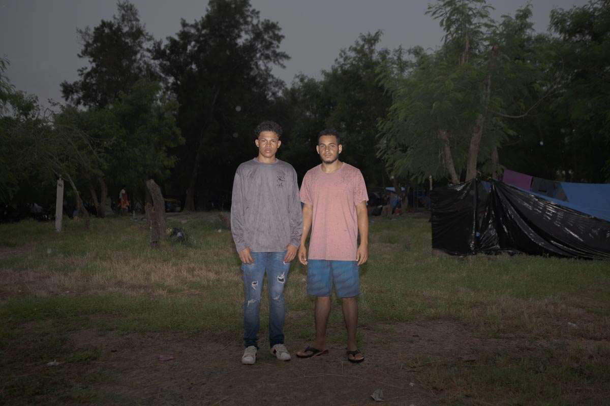 El nicaragüense Juan Francisco Ruedas Juárez, (izquierda) y su amigo colombiano Jimmy Jesús Estrada (derecha) posan para un retrato en el campamento de Matamoros, México. Foto de Fred Ramos para Divergentes.